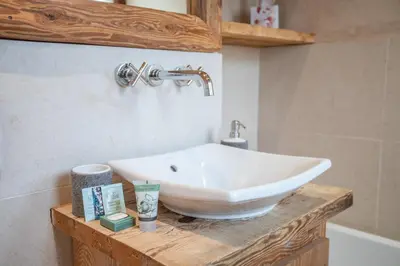 a bathroom with a white sink on a wooden counter at Les Corneilles - Appartement in Megève
