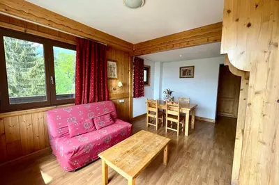 a living room with a red couch and a table at Premier de Cordée in Combloux