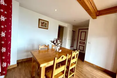 a dining room with a wooden table and chairs at Premier de Cordée in Combloux