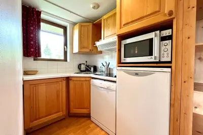 a kitchen with a white refrigerator and a microwave at Premier de Cordée in Combloux