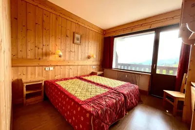 a bedroom with a bed and a large window at Premier de Cordée in Combloux