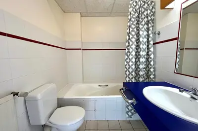 a bathroom with a toilet and a tub and a sink at Premier de Cordée in Combloux