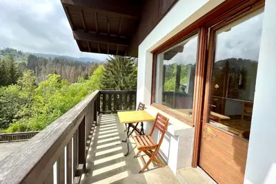 a balcony of a house with a table and chairs at Premier de Cordée in Combloux