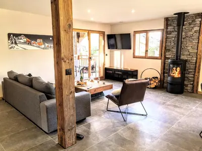 a living room with a couch and a wood stove at Chez Lucienne, jacuzzi et sauna in Samoëns