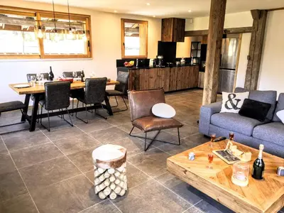 a living room with a couch and a table at Chez Lucienne, jacuzzi et sauna in Samoëns