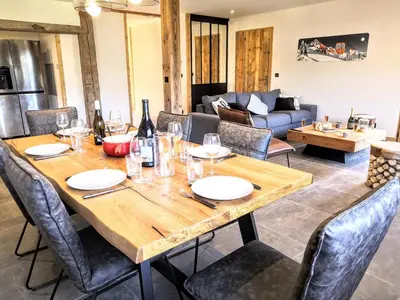 a dining room with a table and a couch at Chez Lucienne, jacuzzi et sauna in Samoëns
