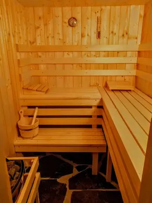 a wooden sauna with a bench in it at Chez Lucienne, jacuzzi et sauna in Samoëns
