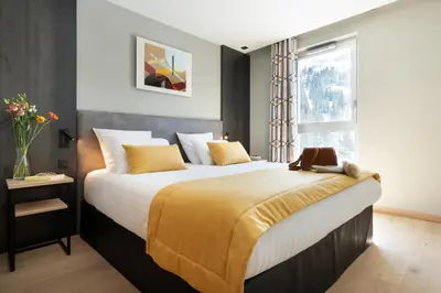 a bedroom with a large bed and a window at MGM Hôtels & Résidences - Résidence Alhéna in Flaine