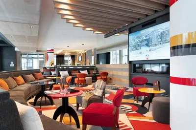 a lobby with a couch and tables and chairs at MGM Hôtels & Résidences - Résidence Alhéna in Flaine