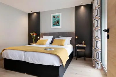a bedroom with a large bed with yellow pillows at MGM Hôtels & Résidences - Résidence Alhéna in Flaine