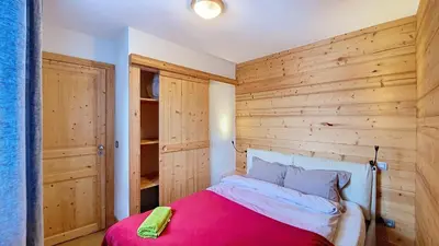 a bedroom with a wooden accent wall and a bed at Aiguille Rouge in Chamonix-Mont-Blanc
