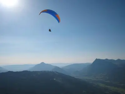 a kite is flying in the sky over mountains at Appartement Les Dents Blanches - Samöens Centre in Samoëns
