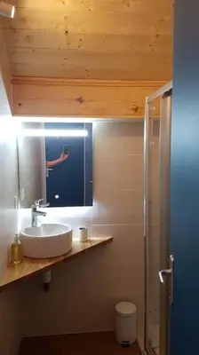 a person taking a picture in a bathroom mirror at Appartement Les Dents Blanches - Samöens Centre in Samoëns