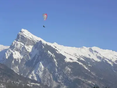 a helicopter flying over a snow covered mountain at Appartement Les Dents Blanches - Samöens Centre in Samoëns