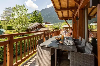 a wooden balcony with a table and chairs on it at Chalet du Dard - Chamonix All Year in Chamonix-Mont-Blanc