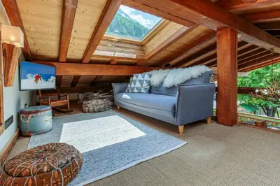 a living room with a blue couch and a tv at Chalet du Dard - Chamonix All Year in Chamonix-Mont-Blanc