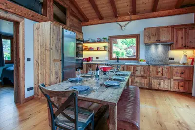 a kitchen with a wooden table with plates on it at Chalet du Dard - Chamonix All Year in Chamonix-Mont-Blanc