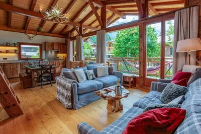 a living room with a blue couch and a table at Chalet du Dard - Chamonix All Year in Chamonix-Mont-Blanc