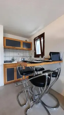 a kitchen with a counter with chairs at a bar at Super appartement Cocooning vu Mont Blanc in Sallanches