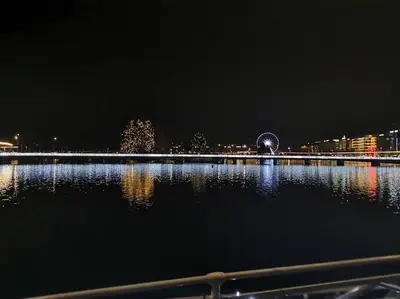 a view of a city at night with a body of water at Super appartement Cocooning vu Mont Blanc in Sallanches