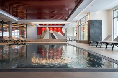 a pool in a building with chairs and a fountain at MGM Hôtels & Résidences - Hôtel Alhéna in Flaine