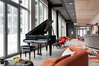 a piano in a room with chairs and windows at MGM Hôtels & Résidences - Hôtel Alhéna in Flaine
