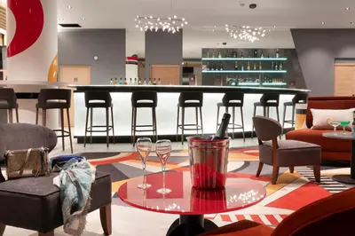 a bar with two wine glasses on a table at MGM Hôtels & Résidences - Hôtel Alhéna in Flaine