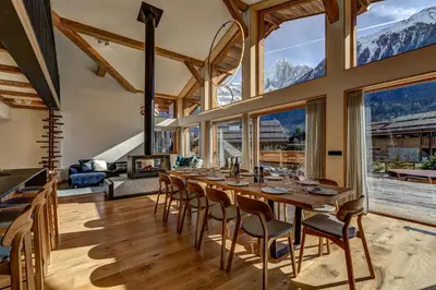 a dining room with a table and chairs and mountains at Chalet Trois Soeurs in Chamonix-Mont-Blanc
