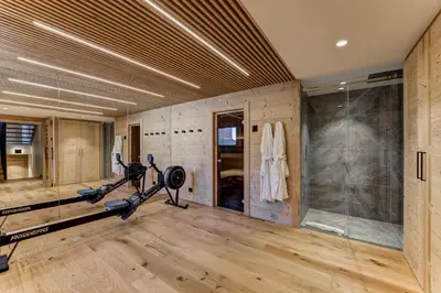 a gym with exercise equipment and a glass wall at Chalet Trois Soeurs in Chamonix-Mont-Blanc