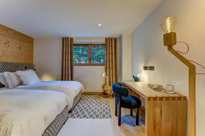 a bedroom with a bed and a desk with a chair at Chalet Trois Soeurs in Chamonix-Mont-Blanc