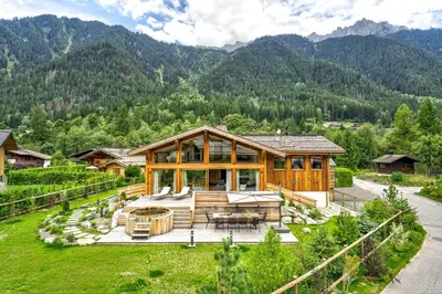 a large wooden house in the middle of a mountain at Chalet Trois Soeurs in Chamonix-Mont-Blanc