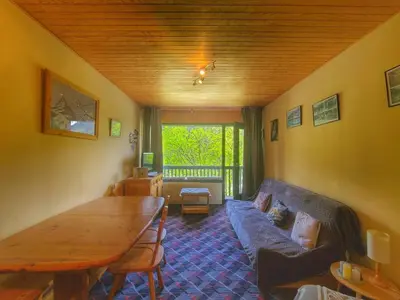 a living room with a blue couch and a wooden table at Appart. 38m² pour 6 pers, balcon sud, pied des pistes - FR-1-687-115 in Arâches-la-Frasse