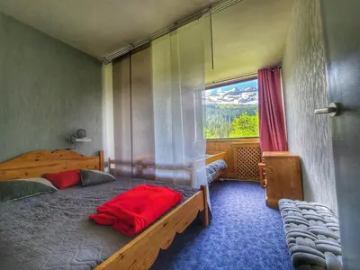 a bedroom with a large bed and a window at Appart. 38m² pour 6 pers, balcon sud, pied des pistes - FR-1-687-115 in Arâches-la-Frasse