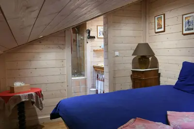 a bedroom with a blue bed and wooden walls at Le Vallorcin, chalet le Sizeray vallée de Chamonix & Mont Blanc - by ImmoConciergerie in Vallorcine