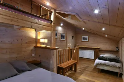 a log cabin bedroom with a bed and a bench at Les Posettes, chalet vallée de Chamonix - Mont Blanc by ImmoConciergerie in Vallorcine