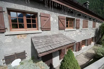 a house with brown windows and a wooden porch at Les Posettes, chalet vallée de Chamonix - Mont Blanc by ImmoConciergerie in Vallorcine