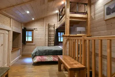 a bedroom in a log cabin with a bed and stairs at Les Posettes, chalet vallée de Chamonix - Mont Blanc by ImmoConciergerie in Vallorcine
