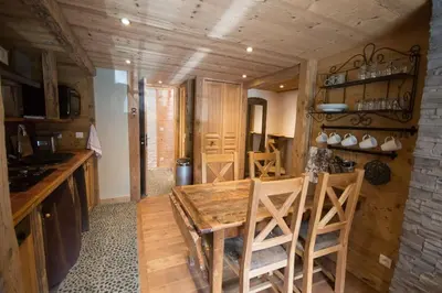 a kitchen with a wooden table and some chairs at Les Posettes, chalet vallée de Chamonix - Mont Blanc by ImmoConciergerie in Vallorcine