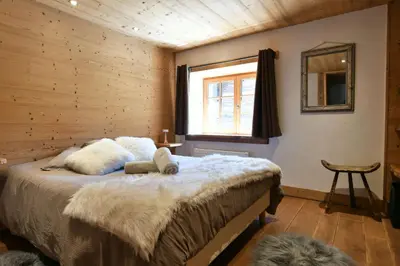 a bedroom with a bed in a wooden room at Les Posettes, chalet vallée de Chamonix - Mont Blanc by ImmoConciergerie in Vallorcine