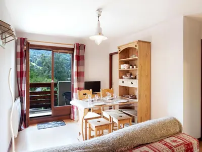 a balcony of a house with a table and chairs at Studio Les chalets du soleil by Interhome in Saint-Gervais-les-Bains