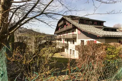 a large white house with a gambrel roof at Le Quatre - 75m2 Charmant Duplex - Central - 8-10 pax 3ch in Saint-Gervais-les-Bains