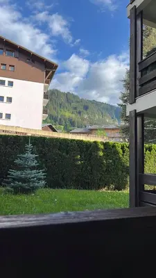 a view of a building and a lawn with a christmas tree at Studio avec coin montagne au pied des pistes in Megève