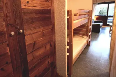 a room with a wooden door and a bunk bed at Studio avec coin montagne au pied des pistes in Megève