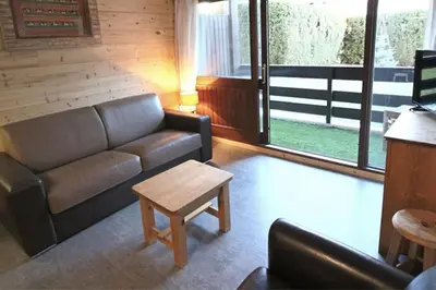 a living room with a couch and a coffee table at Studio avec coin montagne au pied des pistes in Megève