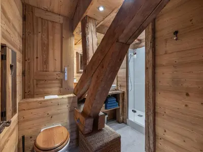 a wooden bathroom with a toilet and a staircase at Nid douillet au cœur de Megeve in Megève