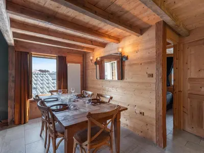a wooden dining room with a table and chairs at Nid douillet au cœur de Megeve in Megève