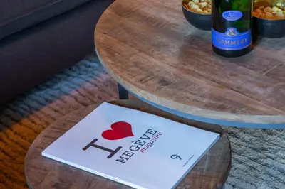 a table with a wine bottle and a sign on it at Nid douillet au cœur de Megeve in Megève