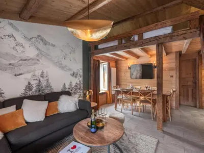 a living room with a couch and a dining room at Nid douillet au cœur de Megeve in Megève