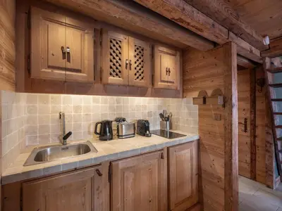 a kitchen with wooden cabinets and a sink in a cabin at Nid douillet au cœur de Megeve in Megève