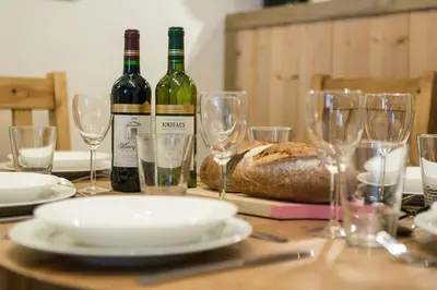 a table with two bottles of wine and glasses at Apartment Grepon 6 Incredible Mont Blanc View Chamonix in Chamonix-Mont-Blanc